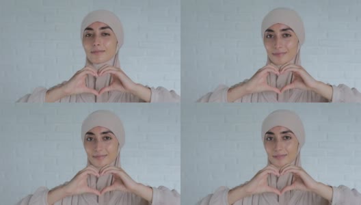 可爱的穆斯林阿拉伯妇女，戴着头巾，用手表达爱意，浪漫的情感，可爱的，幸福的，和平的姿态。全世界的爱，是穆斯林妇女对全世界的爱的象征高清在线视频素材下载