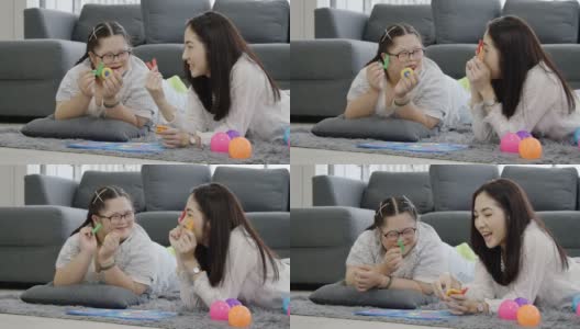 亚洲自闭症女儿谈话母亲在客厅幸福的微笑。妈妈在家教孩子语言。为孩子练习沟通技巧。快乐的家庭节日活动长周末。高清在线视频素材下载