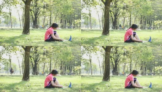 一名年轻女子在公园里系鞋带高清在线视频素材下载