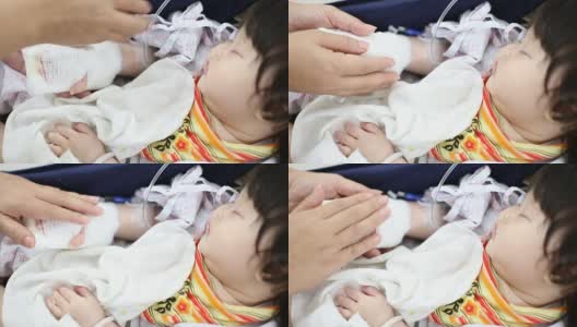 生病的婴儿在医院的安全座椅上接受生理盐水治疗高清在线视频素材下载