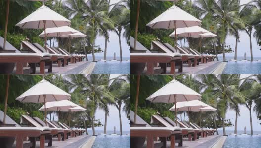 热带度假村游泳池附近的沙滩椅高清在线视频素材下载