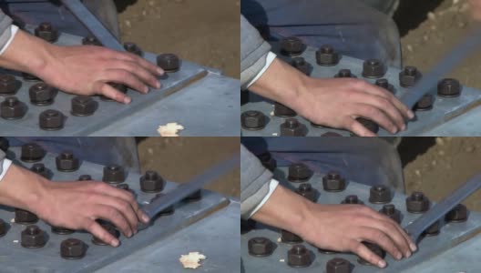 工人用扳手拧紧固定铁路桥金属板的螺丝高清在线视频素材下载