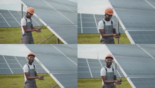 工程师在户外测量太阳能电池板的安培数。穿着灰色工作服的非洲人在户外测量太阳能电池板的阻力。有能力的技术员在现场检查时使用万用表高清在线视频素材下载