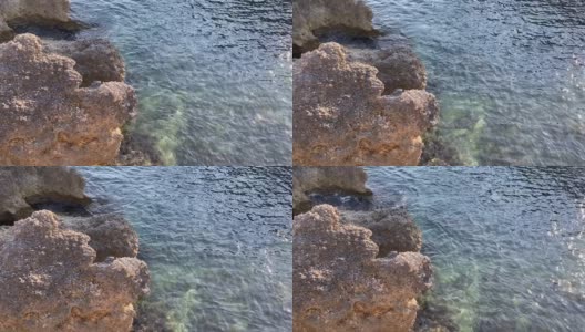 蓝绿色的海水波纹背景。透明的绿色海水表面在热带天堂泻湖。美丽的海景。地中海沿岸岩石嶙峋，海水平静。禅。放松。大自然。高清在线视频素材下载