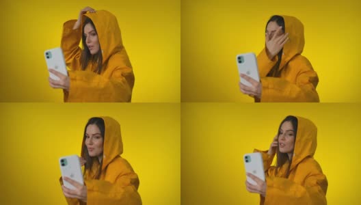 一名身穿亮黄色雨衣的年轻美女在摄影棚里自拍高清在线视频素材下载