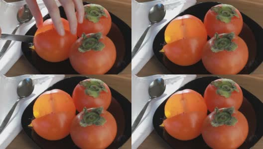 黑盘子上放着成熟的橙柿子高清在线视频素材下载