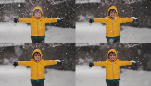 穿着黄色冬衣的滑稽小男孩在下雪时行走。儿童冬季户外活动。高清在线视频素材下载