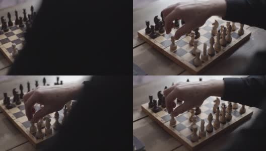 从无法辨认的国际象棋选手的背后的特写视图与棋子在木制的棋盘上执行移动。高清在线视频素材下载