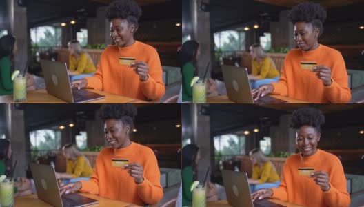 快乐的年轻女子拿着信用卡，在现代自助餐厅通过笔记本电脑在线购物高清在线视频素材下载