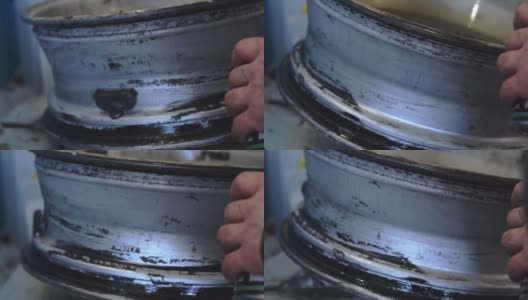 一名汽车修理工在安装轮胎时用密封胶涂抹汽车圆盘。高清在线视频素材下载