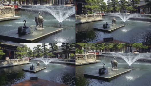 在中国广州宝墨公园的中国建筑楼阁之间的池塘喷泉高清在线视频素材下载