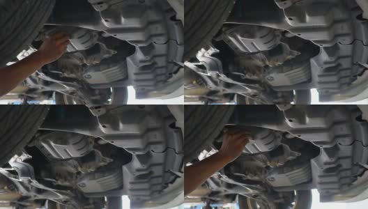 在汽车下工作的汽车修理工高清在线视频素材下载