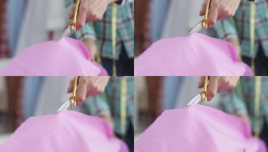 女裁缝用剪刀在工作室特写4k电影慢动作切割粉红色织物高清在线视频素材下载