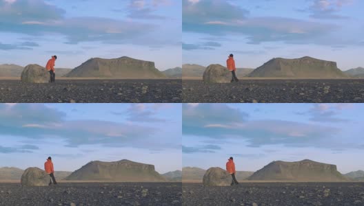 在冰岛的岩石上休息的徒步旅行者高清在线视频素材下载