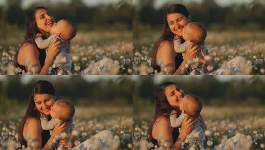 一个年轻快乐的母亲和孩子在一个花田在日落的慢镜头。高清在线视频素材下载