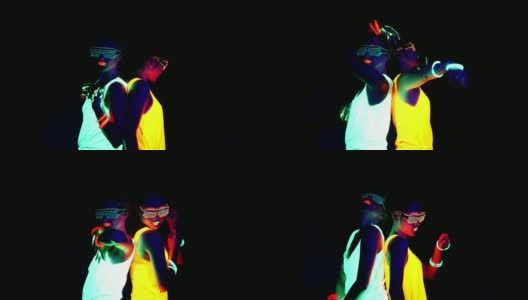迷人的视频性感的网络raver女人拍摄在荧光衣服下的紫外线黑光。两个性感的网络发光raver女人拍摄在紫外线黑光下荧光衣服，派对概念高清在线视频素材下载