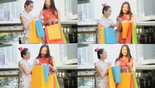 两个漂亮的女人正在看购物袋在城市购物后高清在线视频素材下载