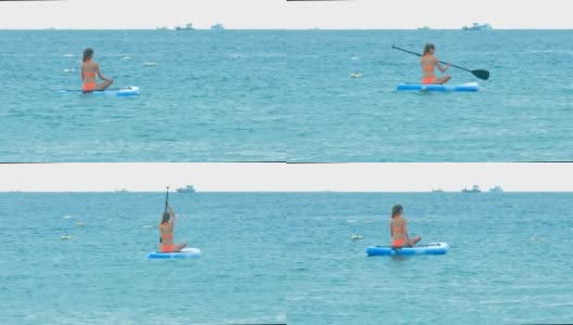 背部女人在比基尼划水板坐在船上高清在线视频素材下载