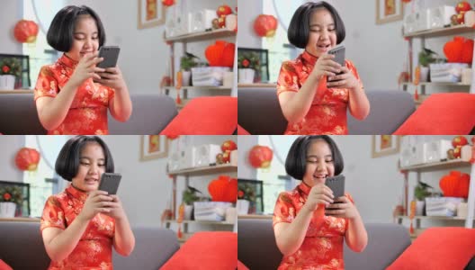 慢镜头，快乐的亚洲女孩用智能手机和她的家人视频通话，中国新年庆祝高清在线视频素材下载