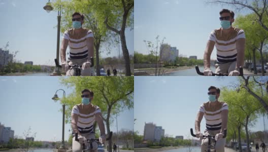 年轻人骑自行车独自在城市海滨，应用所有的保护措施和社会距离在大流行期间高清在线视频素材下载