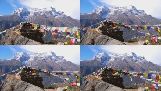 尼泊尔喜马拉雅山昆布纳姆切巴扎村的一堆石头上挂着五颜六色的佛教经幡，在风中飘扬，还有雄伟的孔德里峰。高清在线视频素材下载