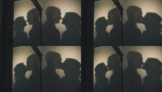 这对恋人在接吻，他们的影子可以在房间的墙上看到。有趣的特写镜头高清在线视频素材下载