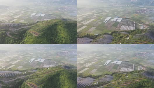 俯瞰山顶的太阳能农场和地面上的农场高清在线视频素材下载