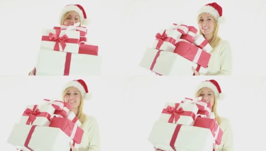 快乐的年轻女子戴着圣诞帽，拿着礼物高清在线视频素材下载