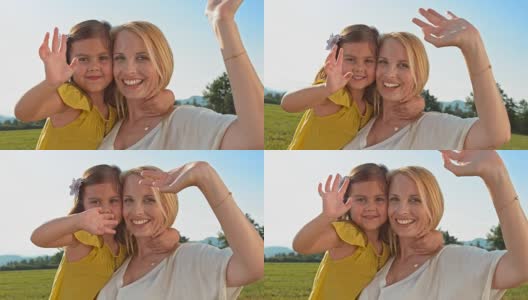 母亲和女儿在草地上对着镜头挥手高清在线视频素材下载