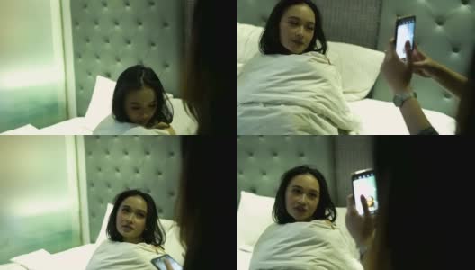 亚洲女性用带闪光灯的智能手机给她最好的朋友拍照高清在线视频素材下载