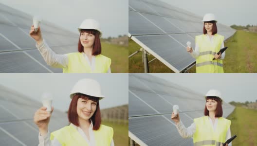 戴着头盔的女人站在太阳能农场拿着灯泡。一个穿着制服戴着白色头盔的女人站在太阳能农场。女工程师在工作中使用数码平板电脑。可再生电力的概念高清在线视频素材下载