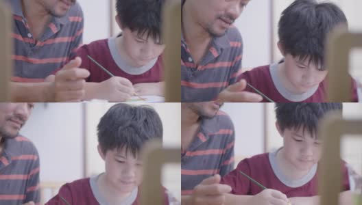 亚洲男孩和父亲在家里画水彩画高清在线视频素材下载