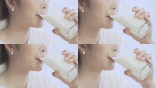 美丽的年轻女子喝牛奶是健康的微笑高清在线视频素材下载