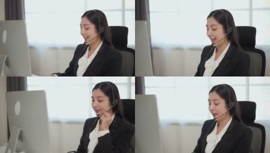 Smiley亚洲商务女接待员戴耳机视频会议电话，在电脑上通过网络摄像头在网上聊天，客户支持服务。高清在线视频素材下载