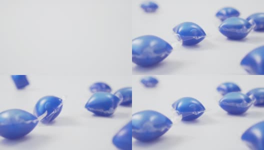 蓝色洗衣粉落在白色背景上的豆荚的特写。高清在线视频素材下载