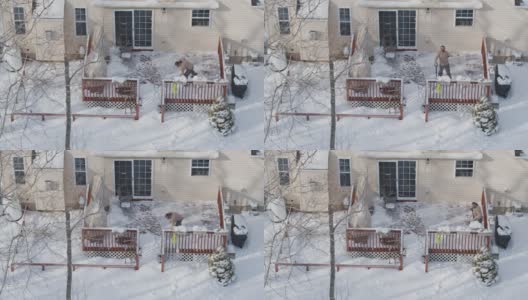 一个成年人在冬天下雪后用铲子清理门廊上的积雪。鸟瞰图直接在无人机视频上方。高清在线视频素材下载