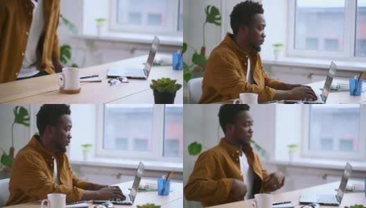 非洲人在家庭办公室用笔记本电脑打字。记者写一篇文章。20多岁的美国人高清在线视频素材下载