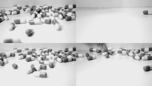 黑色和白色尖锐清晰原药药丸胶囊跌落溢出在柜台顶部编辑的效果为医疗行业高清在线视频素材下载