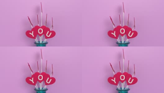 《我爱你》在4K分辨率的粉色背景下写在花瓶里的红心形状上高清在线视频素材下载