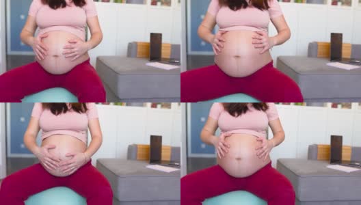 孕妇在家中客厅里的健身球上进行分娩前的肌肉锻炼高清在线视频素材下载