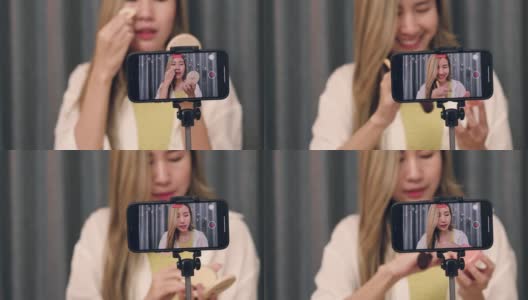 年轻的亚洲女性美妆博主用智能手机录制了化妆品教育教程视频，并在社交媒体(sns)上发布。高清在线视频素材下载