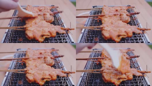 烤，烤，烤新鲜的泰国街头食品，在煤气炉上烤辣味鸡肉和辣酱高清在线视频素材下载