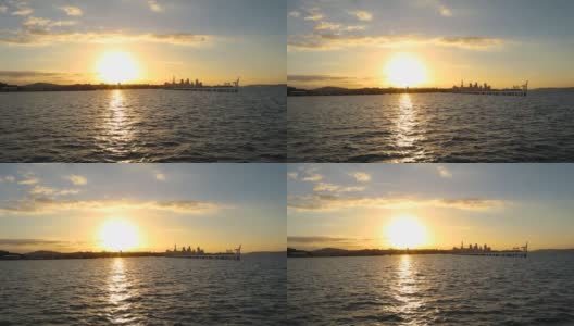 太阳落山时，从水面眺望奥克兰市CBD。从奥拉基湾拍摄。高清在线视频素材下载