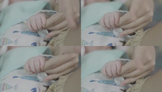 近距离亚洲妈妈手握新生男婴玩他在家里。高清在线视频素材下载