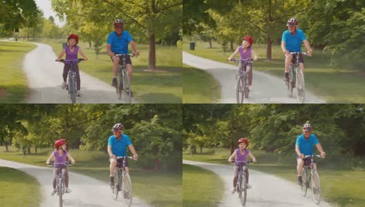 孙女和爷爷骑着自行车穿过公园高清在线视频素材下载