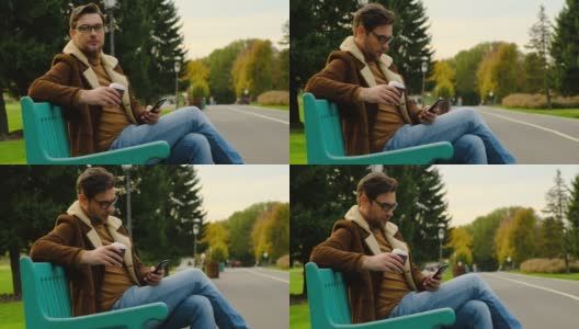 加拿大城市公园，商人在公园长椅上用手机喝咖啡高清在线视频素材下载