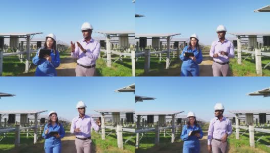 身穿蓝色防护服、安全眼镜、安全帽的亚洲中年工程师与非洲投资者在太阳能农场散步时在平板电脑上做笔记高清在线视频素材下载