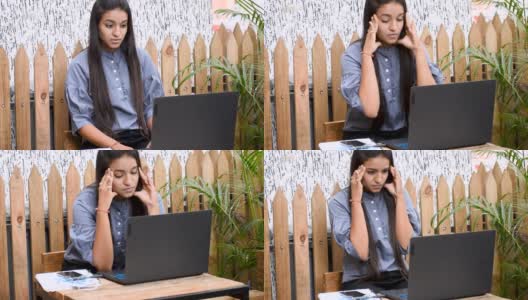 疲惫沮丧的年轻印度女商人因商业失败而沮丧。看着笔记本电脑，感到疲惫和头痛。高清在线视频素材下载