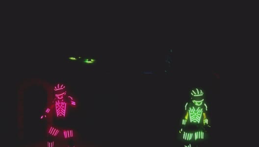 男人穿着发光二极管的服装和彩色的灯跳舞和移动在黑暗的室内或俱乐部。跳舞的人穿着身上有霓虹灯的衣服跳舞。用ARRI相机拍摄高清在线视频素材下载