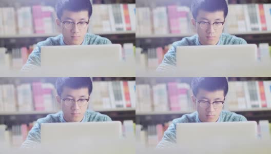 亚洲男学生在图书馆使用笔记本电脑高清在线视频素材下载